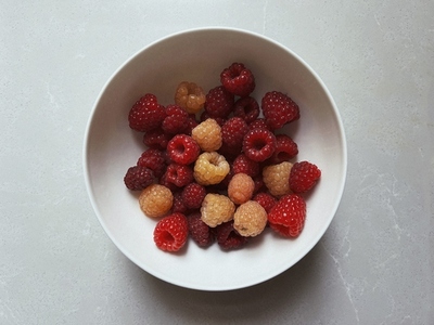 View from above fresh juicy red raspberries in bowl