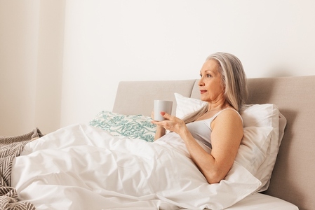 Senior woman with a cup  Aged female in the morning in bedroom