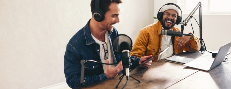 Cheerful podcasters laughing and having a good time in a studio