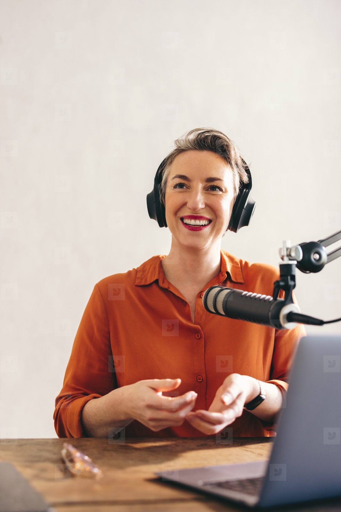 Happy female podcaster smiling in a home studio