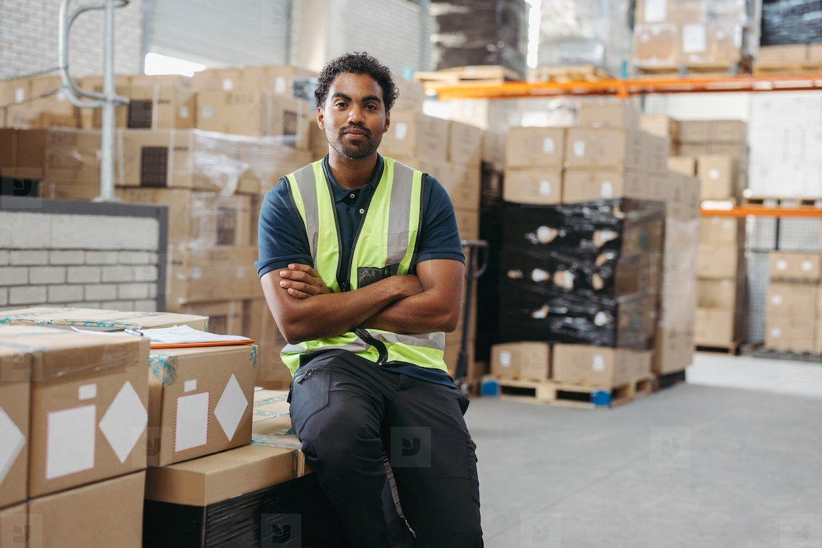 Logistics worker looking at the camera in a distribution warehouse