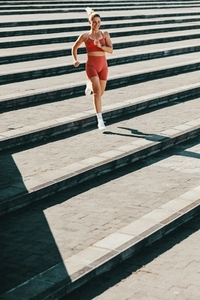 Female runner exercising down the stairs outdoors