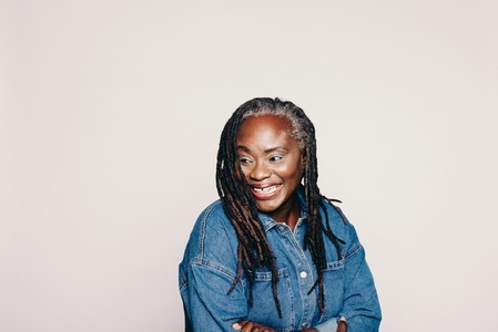 Mature woman with dreadlocks looking away with a happy smile