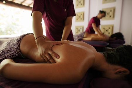 Couple receiving massage at health spa