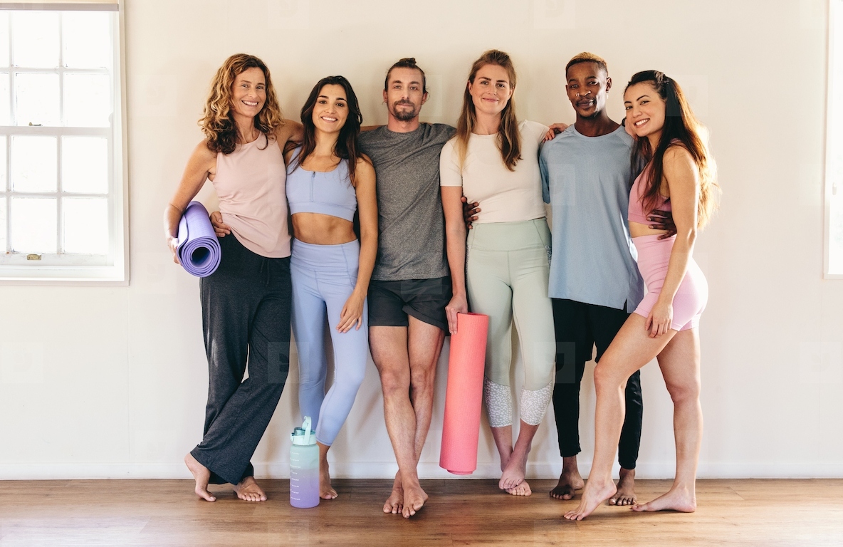 Fitness friends standing against a wall in a yoga studio
