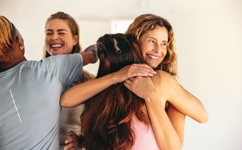 Group of happy people hugging each other after a yoga class