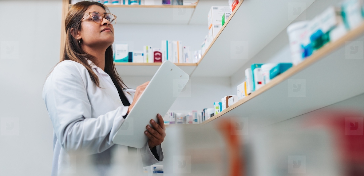 Female pharmacist stocktaking in a chemist