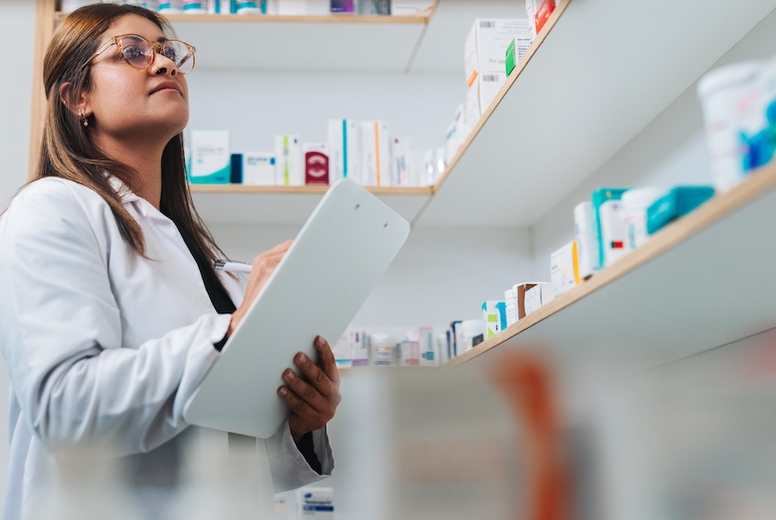Female pharmacist stocktaking in a chemist