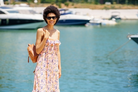 Cheerful African American female near sea in port