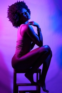Sensual black woman under neon light