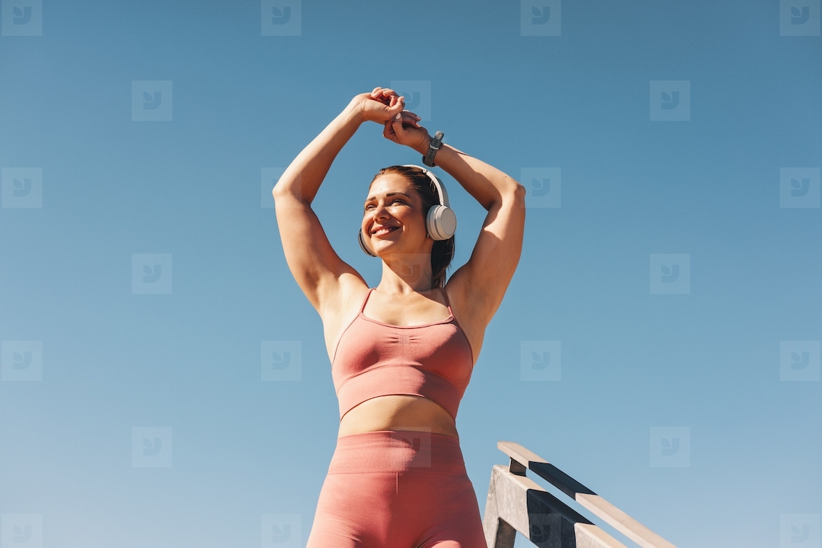 Woman in sportswear stretching her arms outdoors