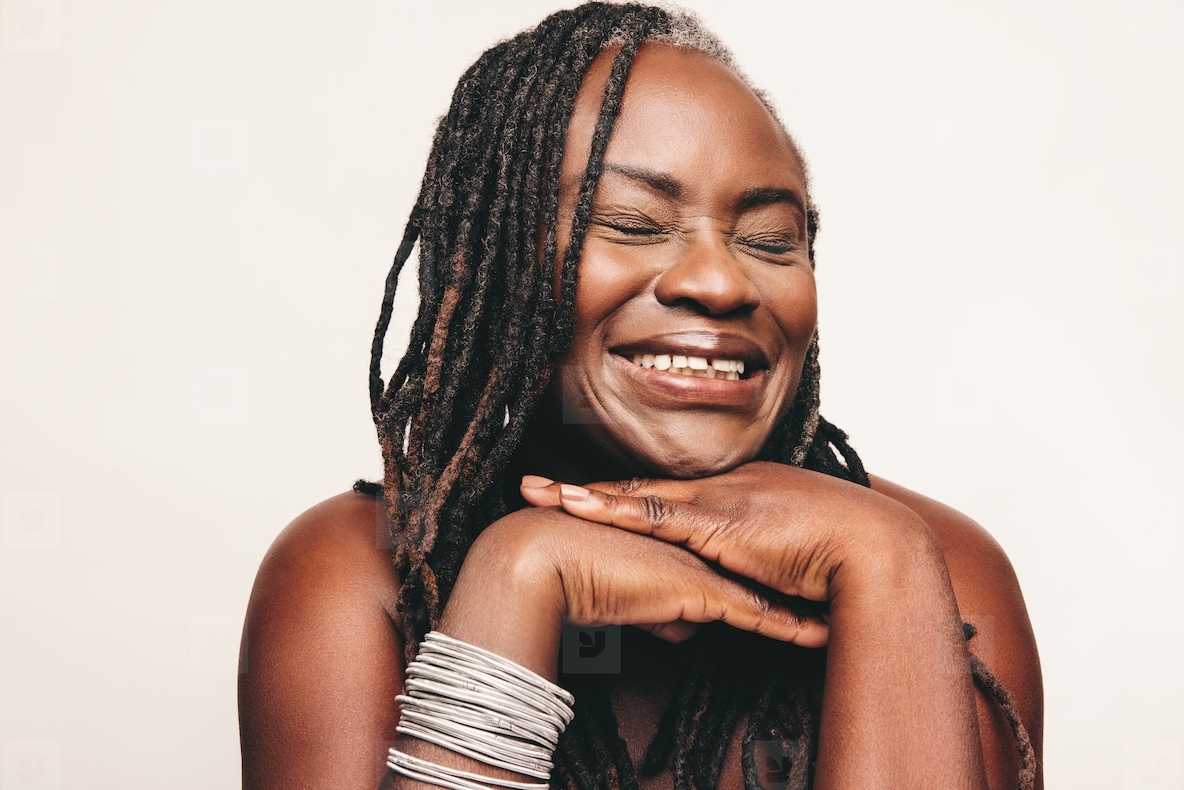 Happy woman with dreadlocks smiling cheerfully in a studio