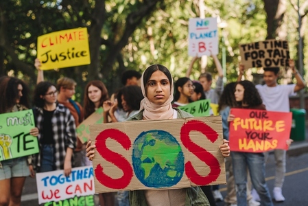 Muslim climate change activist holding a poster