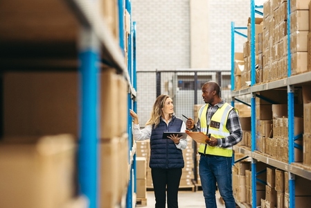 Two warehouse managers recording inventory using smart technology