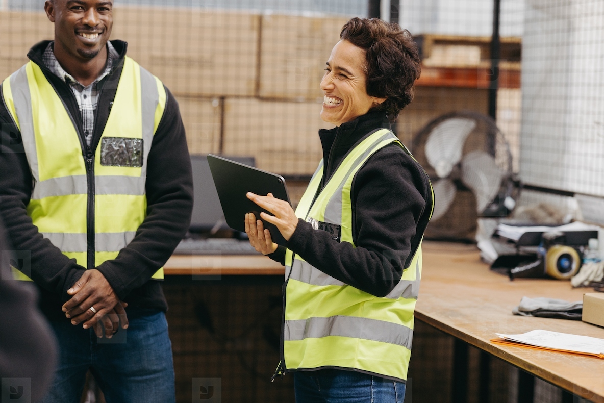 Female warehouse manager smiling happily during a meeting with her team