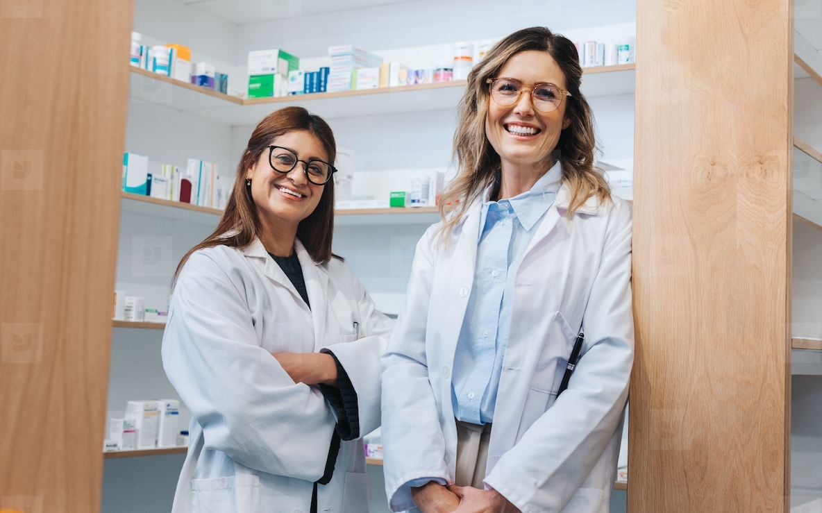 Female pharmacists smiling at the camera in a chemist
