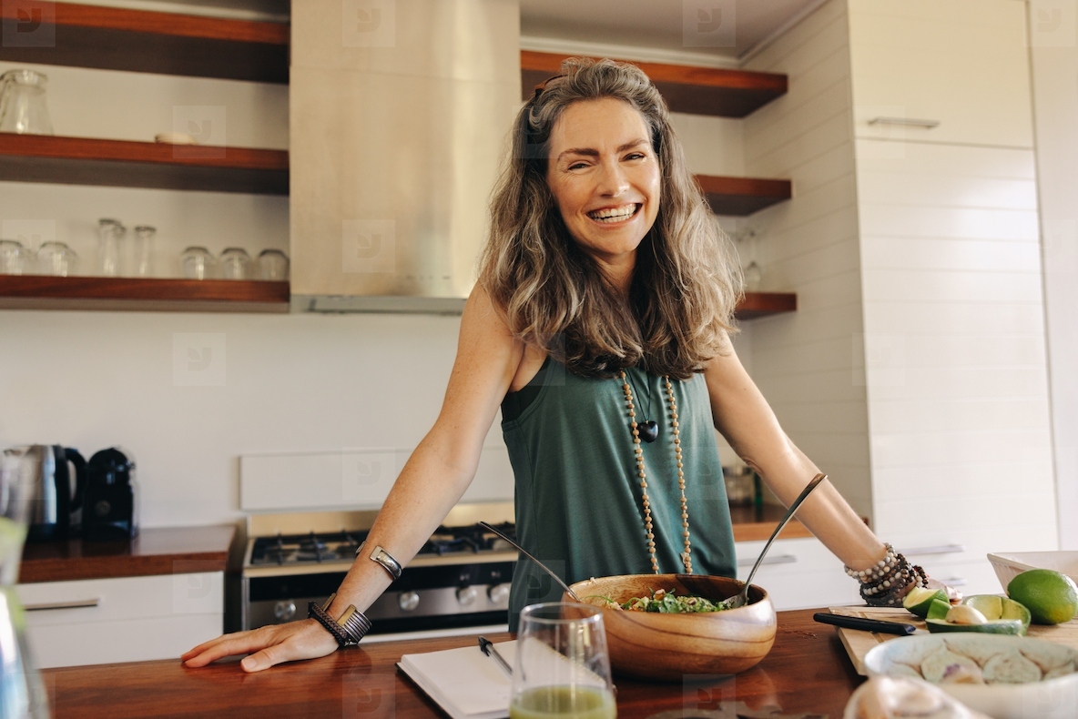 Happy vegan woman preparing a plant-based meal at home