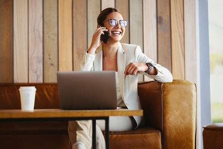 Successful female entrepreneur calling from her smartphone in a work setting