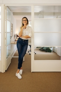 Cheerful businesswoman standing in front of her office