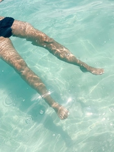 Legs of an unrecognizable woman in transparent ocean water