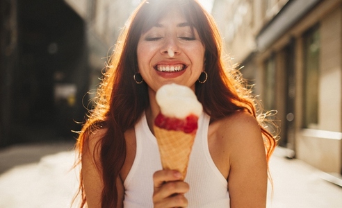 Woman eating ice cream in the city during summer vacation in Europe