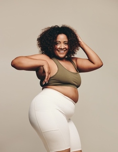 Plus size confidence Woman smiling as she dances in a studio  wearing sports clothing