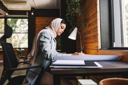 Muslim designer drawing new plans in an office