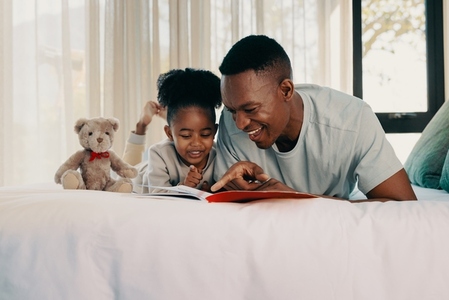 Daddy reads a story with his daughter at home