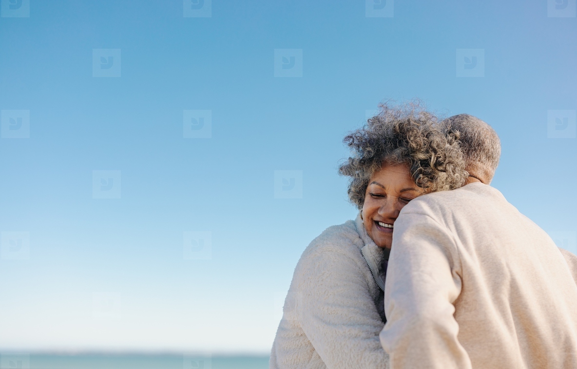 Affectionate senior woman smiling while leaning on her husband