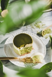 Green matcha cheesecake over grey marble background  top view
