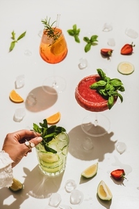 Poplular summer alcohol cocktails and womans hand with mint