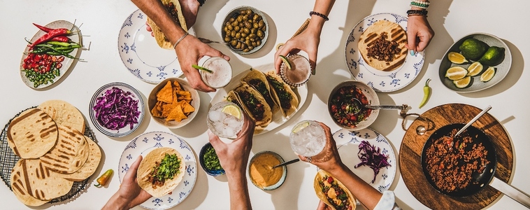 Friends feasting at Mexican style Taco party with beer