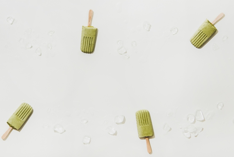 Flat-lay of green matcha coconut popsicles, copy space
