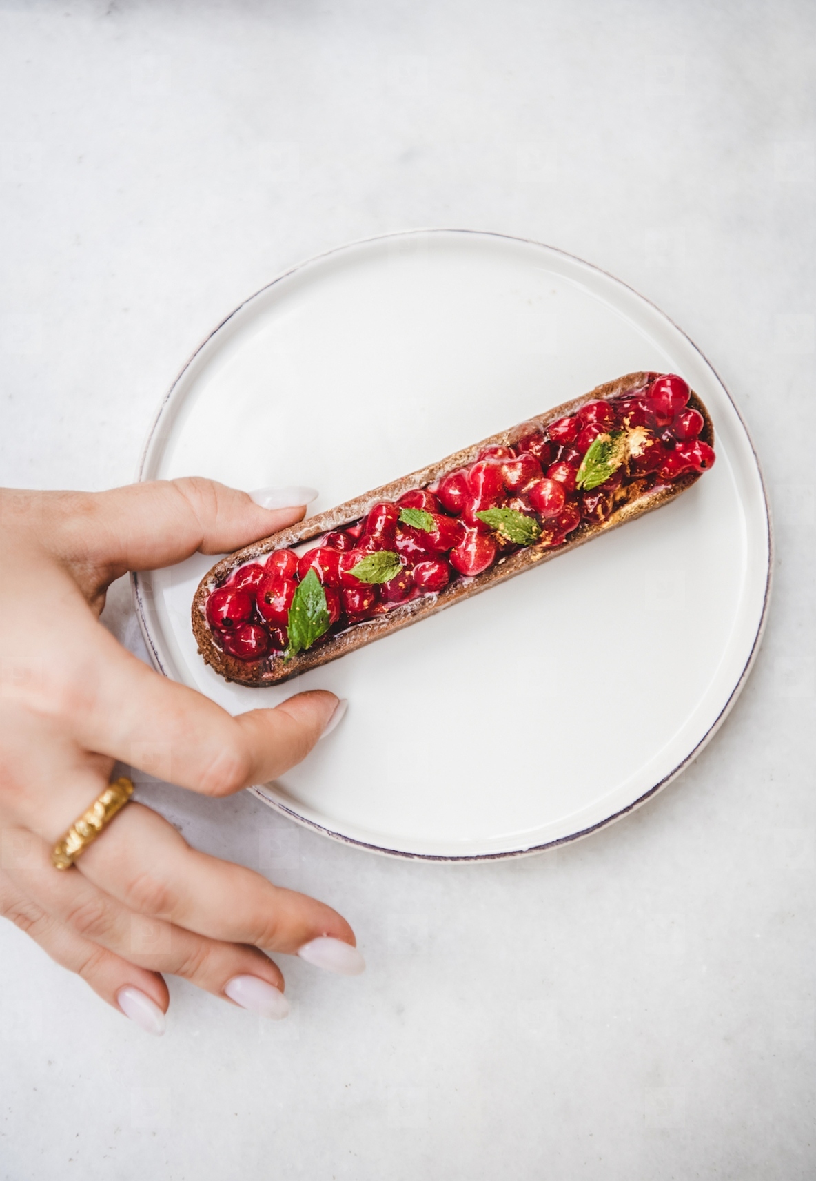Womans hand taking tart with seasonal fresh red currant berries