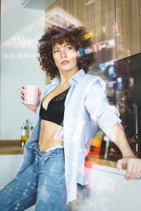 Confident hot woman in black bra with cup of hot drink