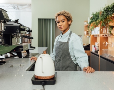 Young barista in a coffee shop  Young female with short hair working as a barista