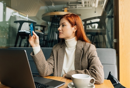 Businesswoman sitting at a table and holding a credit card  willing to pay for her breakfast