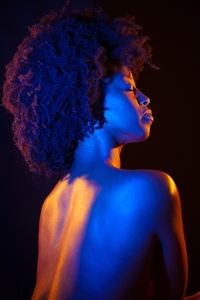 Naked black woman  afro hairstyle  under neon illumination