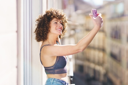 Smiling woman taking selfie on balcony