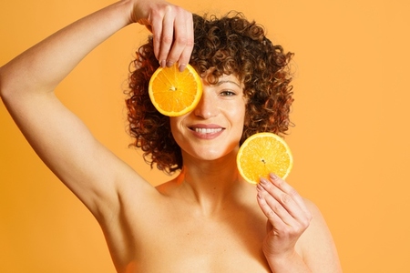 Cheerful female model with slices of orange