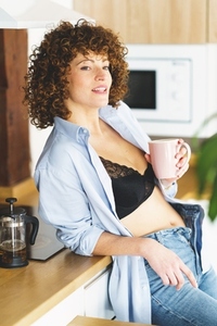 Smiling woman drinking hot tea in morning
