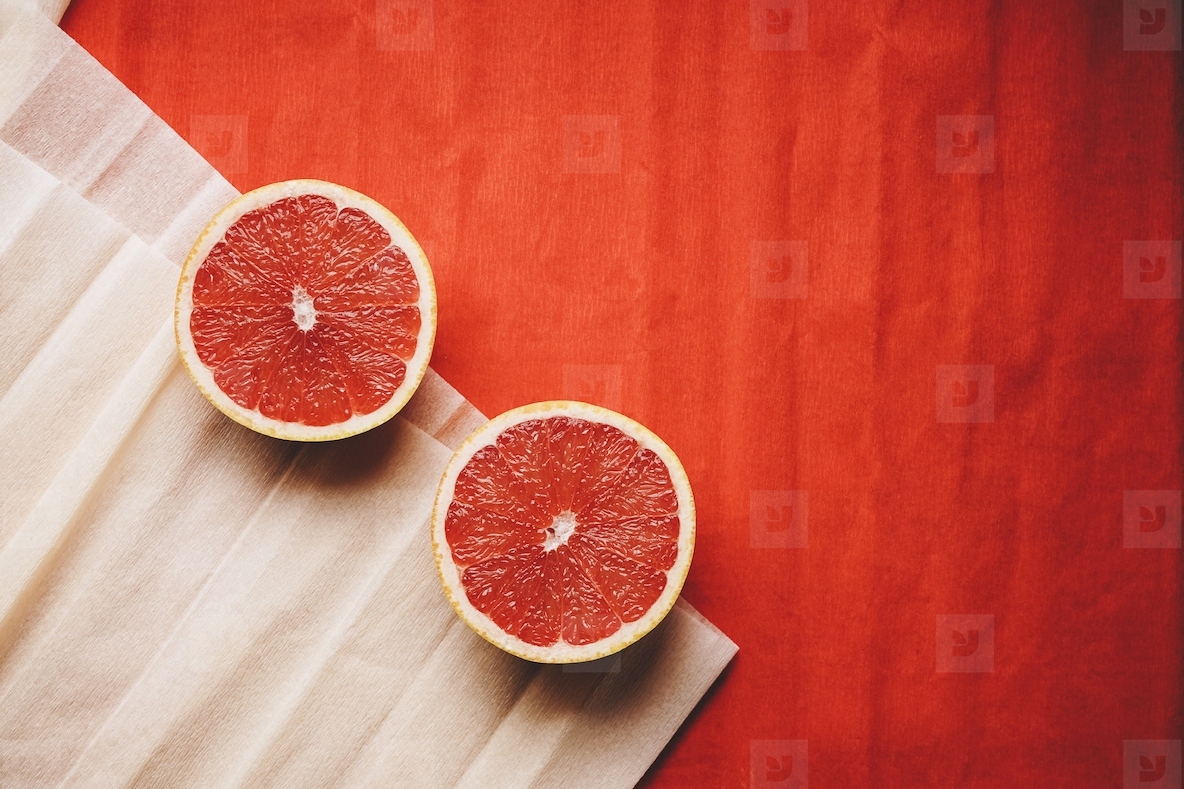 Colorful background in coral and red with fresh open grapefruit