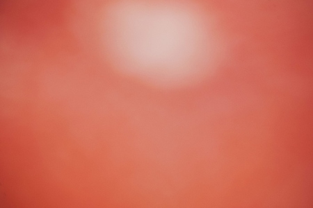 Gradient background image with a blurry pale red circle in a red