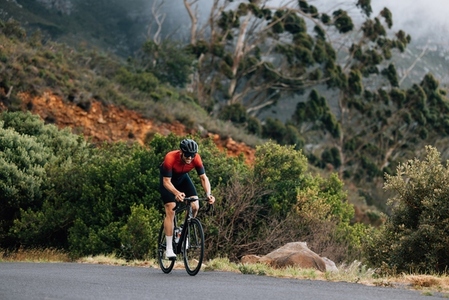 Young male cyclist practicing in wild terrain  Professional triathlete riding road bike
