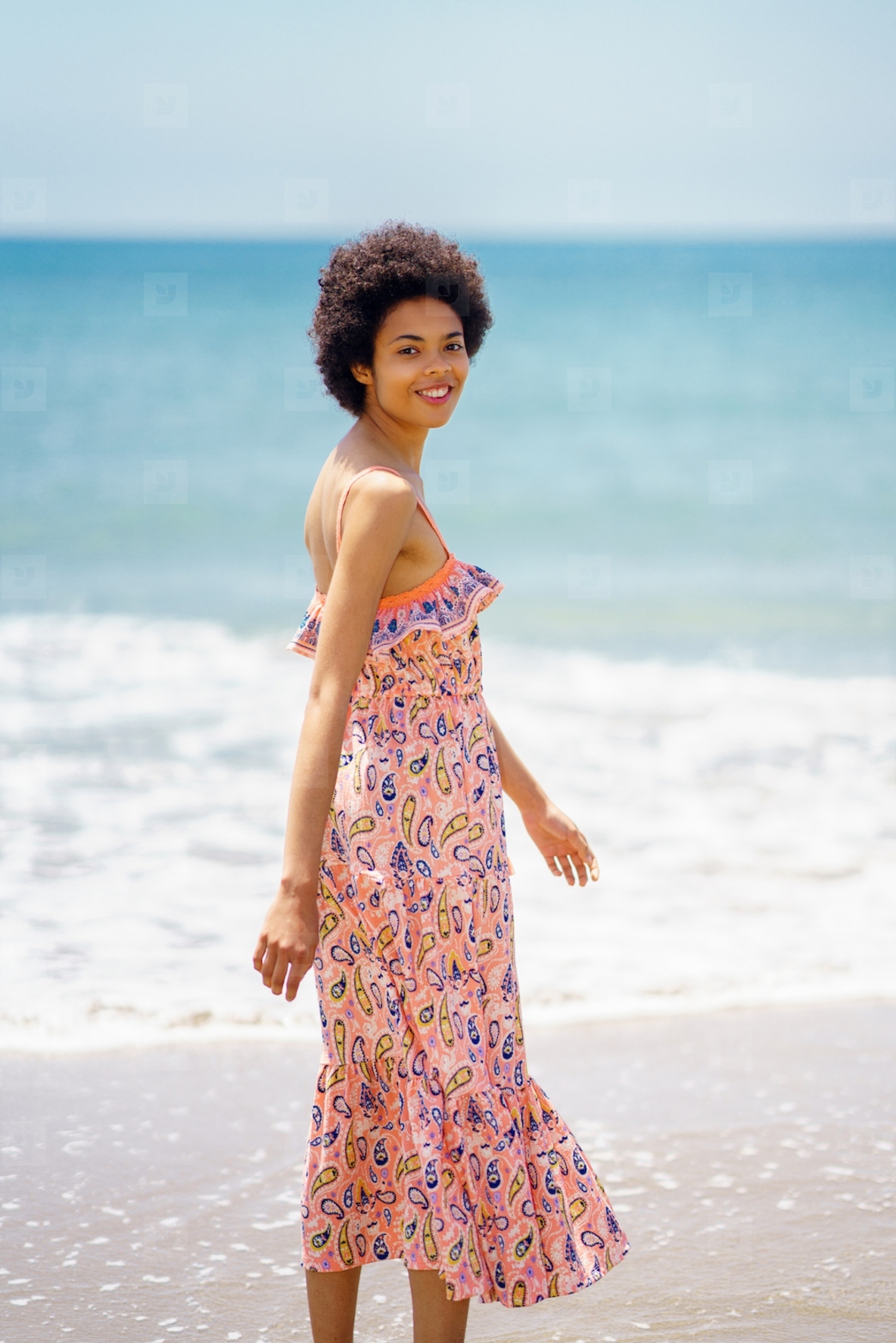 Cheerful ethnic woman enjoying bright summer day at seaside