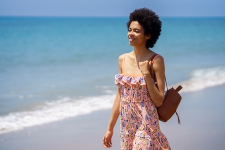 Young ethnic female spending summer vacation on seashore