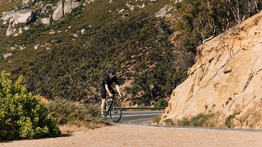Professional male cyclist on a road bike in wild terrain