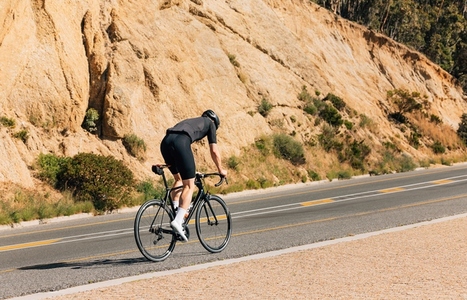 Male cyclist riding on an empty road  Professional cyclist exercising on a road bike