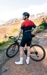 Back view of a cyclist enjoying the view in wild terrain