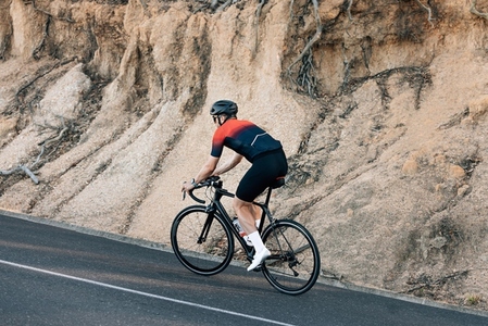 Male cyclist practicing on his road bike at a hill